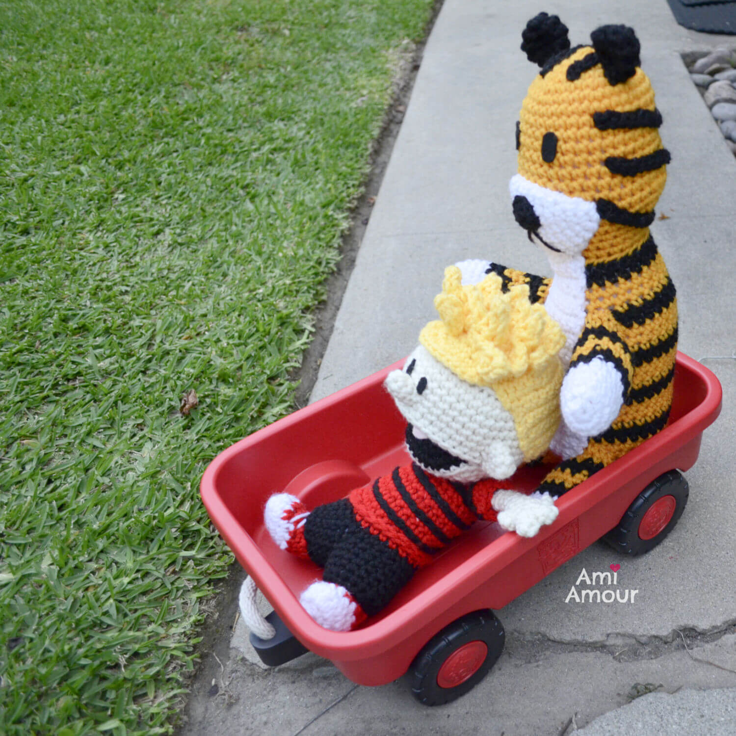 Calvin and Hobbes riding a red wagon