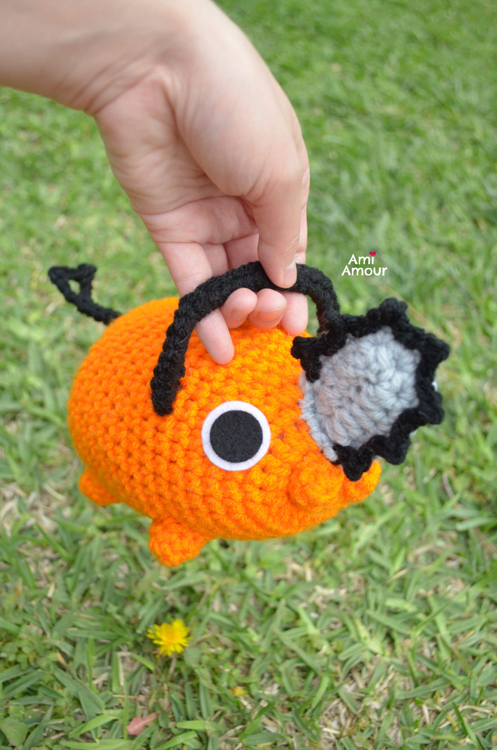 Crochet Pochita being carried by the handle